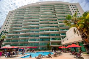 萨利纳斯Hotel Colon Salinas的一座大型建筑,前面设有一个游泳池