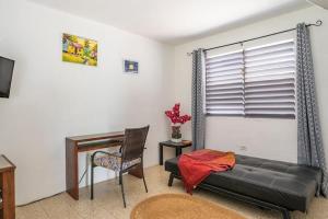 拉纳韦贝Garden Apartment-5min Drive to Beaches, 1 hour Montego Bay, 25 mins Ocho Rios的客厅配有书桌、沙发和桌子