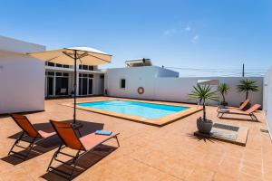 纳萨雷特Villa Dulce Celestino Lanzarote的一个带椅子的庭院和一个位于房子内的游泳池