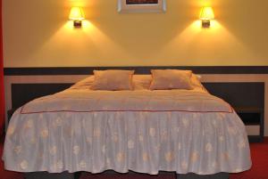 阿马拉达纳酒店的卧室内的一张床位,墙上有两盏灯