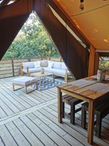 Le lodge cocooning的平台上设有带沙发和桌子的庭院