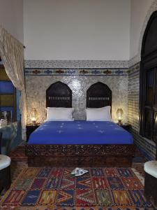 梅克内斯Palais didi的一间卧室配有一张特大号床和蓝色床单
