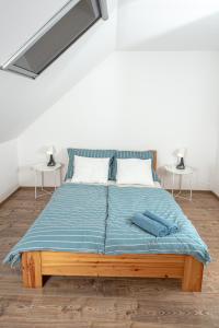 西格利盖特Berkenyeliget Vendégház的一张带蓝色棉被的床和两张桌子