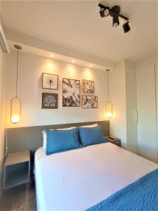 坎皮纳斯Apartamento 1604 no Bosque com um quarto sala cozinha completa e uma vaga de garagem的一间卧室配有一张带蓝色枕头的大床
