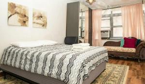 纽约Marvelous 3BR in NYC!的卧室配有床、椅子和窗户。
