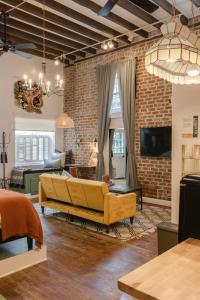 萨凡纳1885 Garden Studio - Historic Heart of Savannah - Pulaski Ward的客厅设有黄色沙发和砖墙