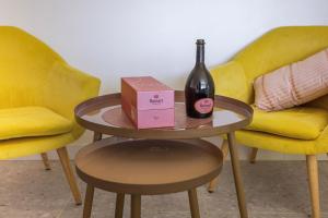马赛LES SUITES LOVE 2 SPA VUE MER PISCINe的两把椅子旁的桌子上放一瓶葡萄酒