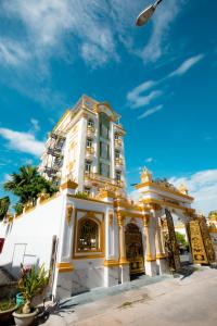 广义KING VILLA QUẢNG NGÃI的一条白色的建筑,在街上装饰着金色的饰物