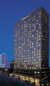 首尔首尔世贸中心奥卓豪景酒店公寓的一座高大的建筑,上面有标志