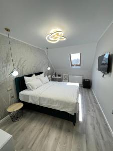 锡比乌Glam Studios的卧室配有一张白色大床和电视。