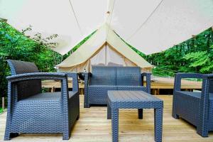 安昙野市Glamping Azumino BASE Polecan - Vacation STAY 49297v的三把椅子、一张桌子和一个帐篷