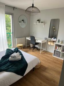 拉蒙维尔圣阿尼Appartement - cœur de Ramonville的一间卧室配有一张床、一张书桌和一张书桌
