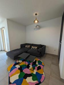 圣路易Appartement moderne tout équipé (Vidéoprojecteur, Domotique etc...)的客厅配有沙发和色彩缤纷的地毯