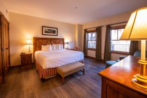 Mount Crested Butte登山广场度假村的酒店客房设有一张床、一张书桌和窗户。