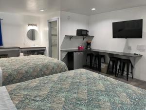巴克斯顿Swell Motel的酒店客房设有两张床和一张书桌及电视