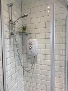 霍斯福斯Four Double Bedroom Home - Free parking and Wi-Fi的浴室铺有白色瓷砖,设有淋浴。