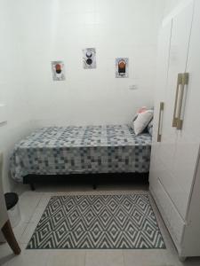 圣保罗Temporada Paulistana exclusivo para Mulheres的一间小卧室,配有床和地毯