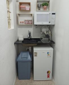圣保罗Temporada Paulistana exclusivo para Mulheres的厨房配有水槽、微波炉和冰箱