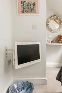 桑盖特Hideaway Cottage - seaview room with shared bathroom的客厅的墙上配有电视