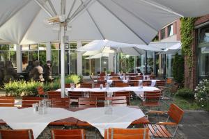 勒斯拉特GenoHotel Forsbach的一排配有白色遮阳伞的桌椅