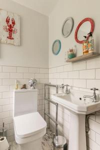 桑盖特Hideaway Cottage - seaview room with shared bathroom的白色的浴室设有卫生间和水槽。