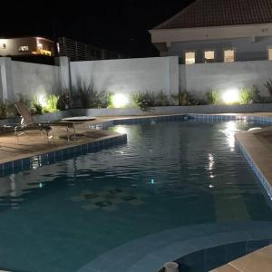 拉热斯POUSADA BLUE GARDEN的夜间在房子里的一个游泳池