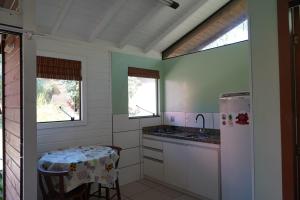 因比图巴Morada Alto Astral的厨房配有桌子和白色冰箱。