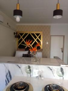 比勒陀利亚Elegant Airbnb的一张桌子,上面有两杯眼镜,花瓶
