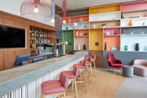 略夫雷加特河畔奥斯皮塔莱特Hampton By Hilton Barcelona Fira Gran Via的餐厅内的酒吧,带红色椅子