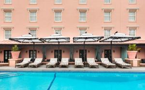 查尔斯顿Mills House Charleston, Curio Collection by Hilton的酒店游泳池设有躺椅和遮阳伞