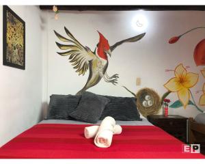 莱瓦镇Beija Flor Hostel的卧室配有一张床上,墙上挂着鸟