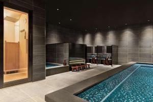 富山DoubleTree by Hilton Toyama的一个带2个休息室的游泳池和一个游泳池