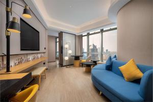 上海上海陆家嘴新梅希尔顿花园酒店的客厅配有蓝色的沙发和电视