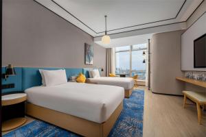 上海上海陆家嘴新梅希尔顿花园酒店的酒店客房设有两张床和电视。