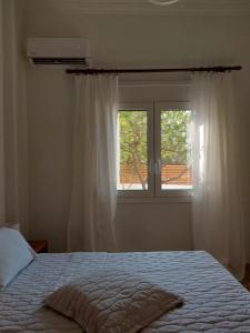 伊罗达MG elounda apt的一间卧室设有一张床和一个窗口