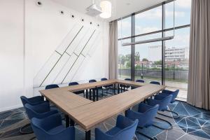 特尔古穆列什Hampton By Hilton Targu Mures的一间会议室,配有木桌和蓝色椅子
