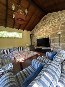MeisSaramagoso的带沙发和石墙的客厅