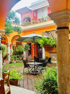 瓦哈卡市Los Arrayanes的庭院配有桌椅和遮阳伞。