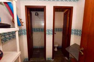 瓜鲁雅Casa aconchegante,perto da praia,com piscina,muito jardim,e pet friendly的带淋浴和卫生间的浴室