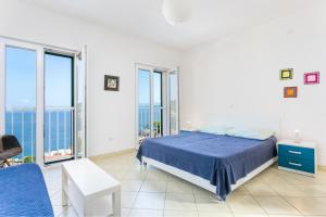 伊格拉恩Holiday house with a parking space Igrane, Makarska - 8332的白色卧室设有蓝色的床和大窗户