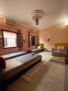 马拉喀什Riad dar sahrawi的一间卧室,配有三张床