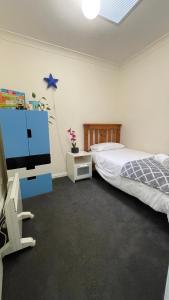 墨尔本Melbourne Inner City Holiday Home Near CBD & Flemington的一间卧室配有一张床和一台平面电视