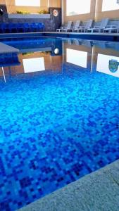 瓦曼特拉Hotel & Cabañas Malinche的铺有蓝色瓷砖的游泳池