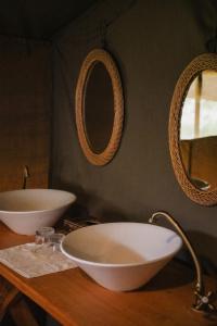 AitongEnkusero Mara的浴室设有2个水槽和2面镜子,位于柜台上