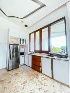 普卡De Summit Villa & View的一间厨房,配有白色的橱柜和大窗户