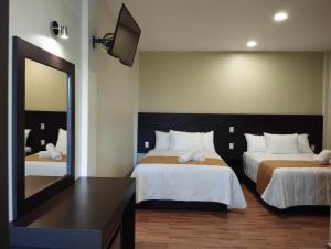 瓦曼特拉Hotel & Cabañas Malinche的酒店客房,设有两张床和镜子