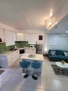格罗斯岛Chalet Belizomi Tropical Villas Studio Villa #3的厨房以及带蓝色沙发的客厅。