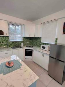格罗斯岛Chalet Belizomi Tropical Villas Studio Villa #3的厨房配有白色橱柜和不锈钢冰箱