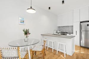 墨尔本NEWLY RENOVATED LARGE 3.5 BDRM HOUSE! BEST OF MELB的白色的厨房配有桌椅