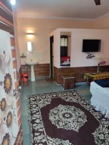 KīhīmVisava Cottages Kihim Beach的客房设有一张床和一间带电视的浴室。
